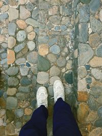 Low section of person standing on cobblestone street