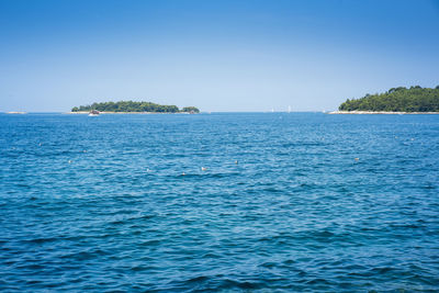 Scenic view of sea against clear blue sky