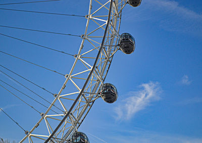 Low angle view of ferris wheel against blue sky