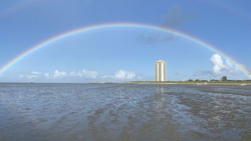 Scenic view of rainbow over sea against sky