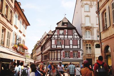 People walking on street amidst buildings in city