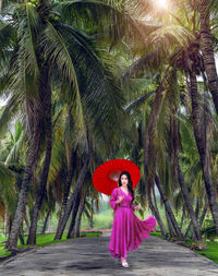 Full length of woman standing on palm trees