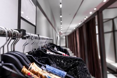 Row of clothes hanging in rack at store