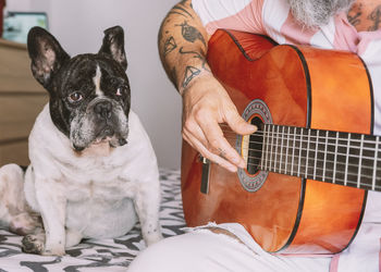 Man playing acoustic guitar to a dog