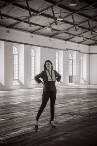 Portrait of young woman standing against wall