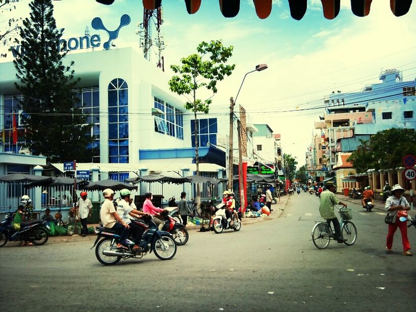 bicycle, transportation, building exterior, land vehicle, architecture, street, built structure, mode of transport, city, men, city life, parking, large group of people, parked, road, car, person, city street, sky