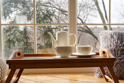 Cup of coffee on the window sill. in the background, a beautiful winter landscape in snow