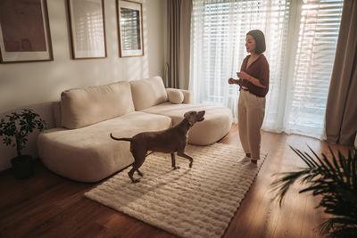 Rear view of man sitting on floor at home