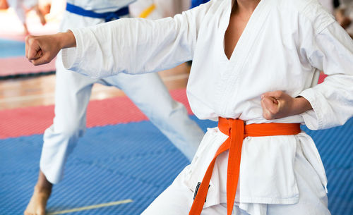 Midsection of women practicing karate