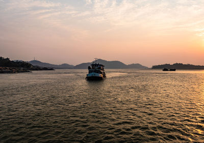 Sunset over river horizon with ship at the centre