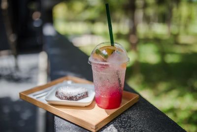 Close-up of food and drink served in tray on retaining wall outdoors