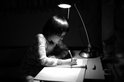 Girl studying in darkroom at home