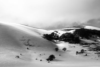 Scenic view of snow covered land against sky