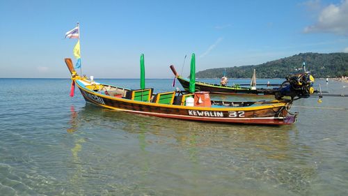 Boat moored on sea against sky