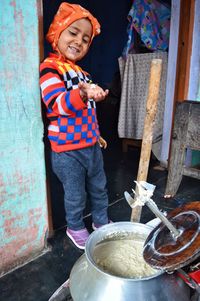 Smiling boy eating food while standing at home