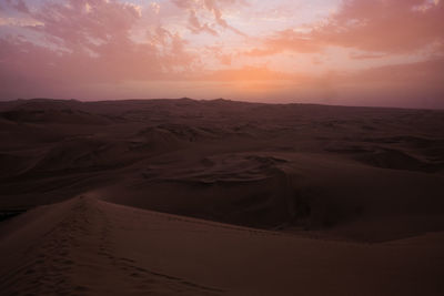 Scenic view of huacachina desert against sky during sunset 