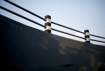 Low angle view of man walking on bridge against clear sky