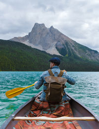 Rear view of woman kayaking in lake