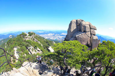 Panoramic view of trees and mountains against blue sky