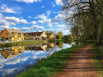 Scenic view of lake by buildings against sky