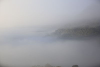 Scenic view of landscape against sky during foggy weather