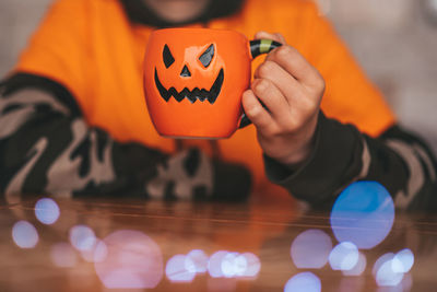 Midsection of man holding jack o lantern