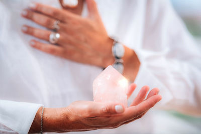 Self-esteem meditation concept. hand holding a rose quartz crystal