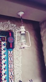 Low angle view of lantern hanging on wall