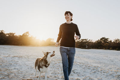 Full length of a dog standing on landscape against clear sky