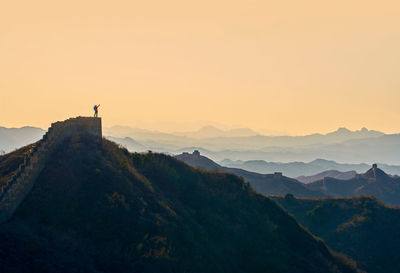 Person on great wall of china at mountain during sunset