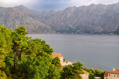Impressive aerial view to the part of kotor bay - red roofs, trees, boats, sea and mountains across
