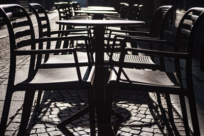 Empty chairs and tables at sidewalk cafe