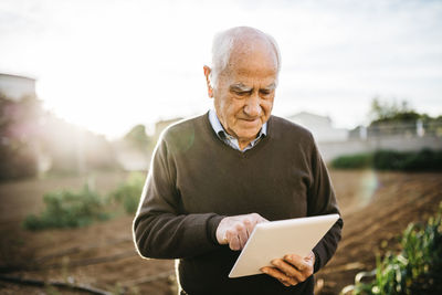 Senior man using tablet in the garden