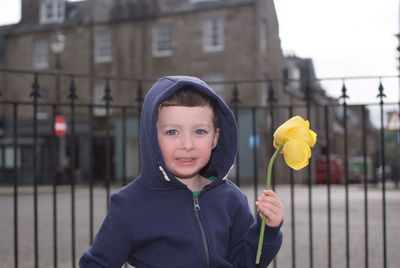 Portrait of cute boy holding yellow outdoors