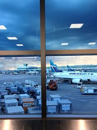 Airplane flying over airport runway against sky