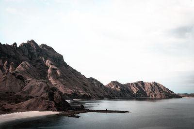 Scenic view of sea and mountains against sky