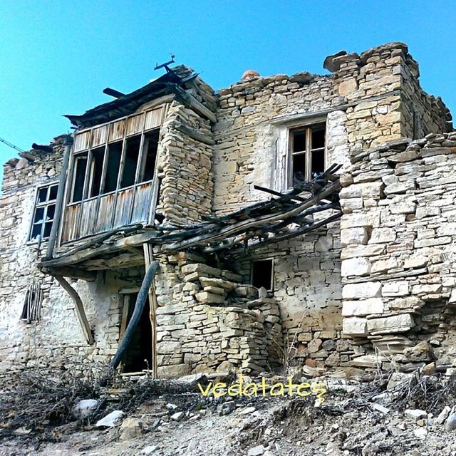 architecture, built structure, building exterior, old, clear sky, low angle view, history, old ruin, abandoned, damaged, obsolete, stone wall, window, run-down, the past, weathered, deterioration, brick wall, ruined, blue