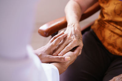 Midsection of couple holding hands