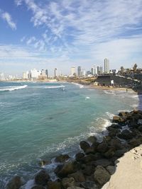 Scenic view of sea by buildings against sky