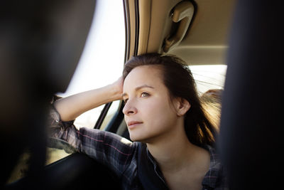 Woman looking away while sitting in car