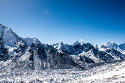 Scenic view of snowcapped mountains against clear blue sky