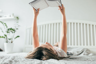 Woman lying on bed at home