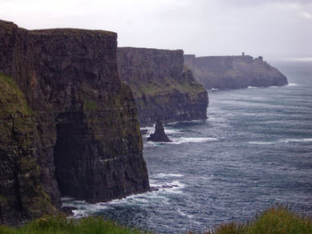 Rock formations by sea against sky