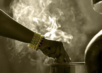 Cropped hand of woman preparing food in kitchen