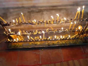 Close-up of illuminated candles on temple against building
