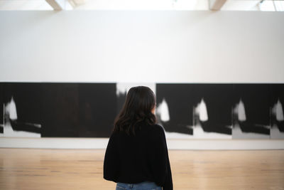 Rear view of woman standing in front of museum