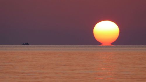 Scenic view of sea against orange sky