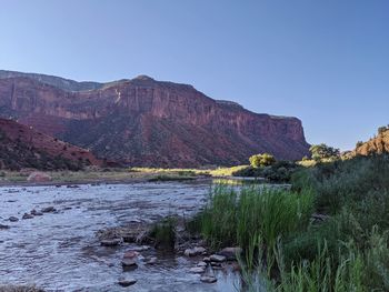 Scenic view of sea and mountains against clear sky