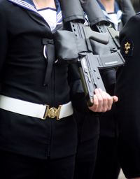 Midsection of military women with guns during parade