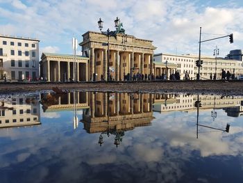 Reflection of building in puddle on lake